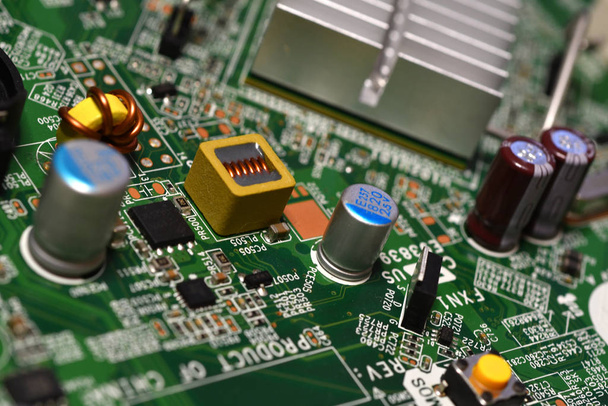 Extreem detail op de elektronische componenten van een modern pc moederbord. Condensatoren, weerstand en andere componenten op de voorgrond. Selectief focussen. - Foto, afbeelding