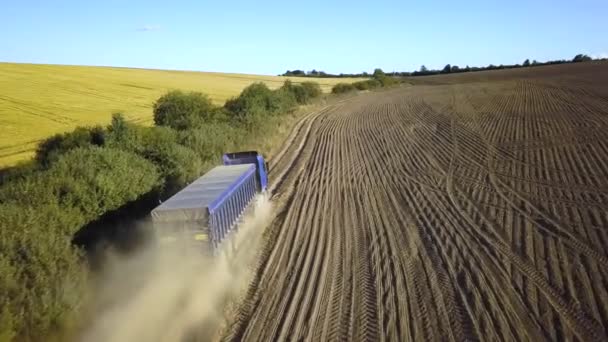 Aerial view of a truck driving on dirt road between plowed fields making lot of dust. - Footage, Video