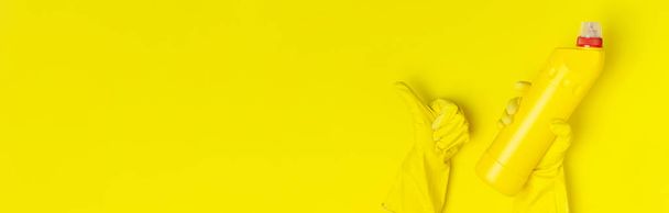 Hausreinigungskonzept. Frauen Hände halten Haushaltschemikalien Desinfektionsmittel antibakterielle Gel gelben Gummihandschuhen Schwamm Lumpen auf gelbem Hintergrund. flache Lagekopierfläche von oben. Reinigungszubehör - Foto, Bild