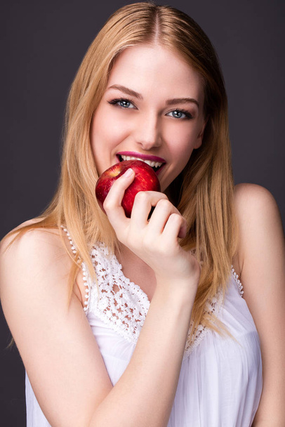 Portrait of a smiling young woman holding almonds in her hands - Foto, Imagem