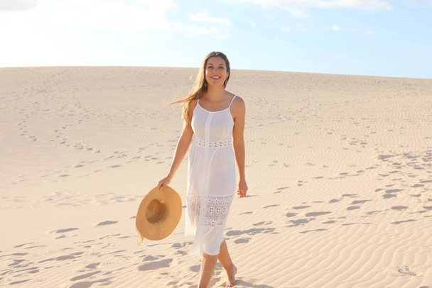 Belle femme avec robe blanche marchant sur les dunes dans le désert, Corralejo, Fuerteventura
 - Photo, image