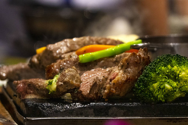 Close up beef on hot dish on fire with vegetables. Live cooking in the restaurant. - Foto, Imagem