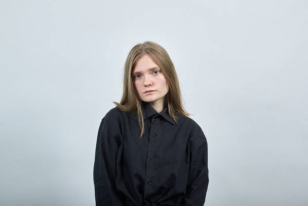 Disappointed young woman on gray wall in studio looking at camera, unhappy. - Fotó, kép