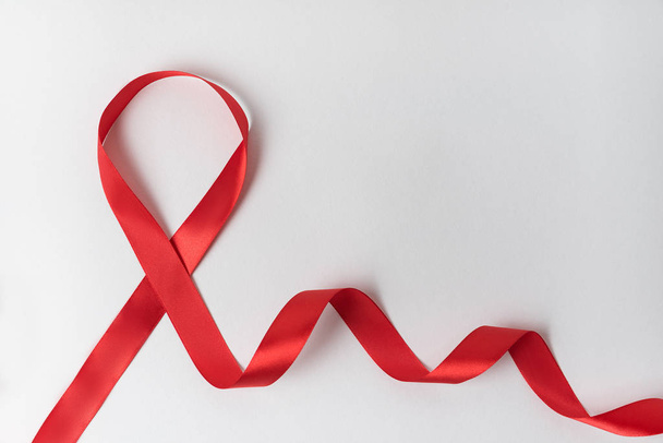 Red ribbon on white background. Aid control symbol. Directly above - Фото, зображення