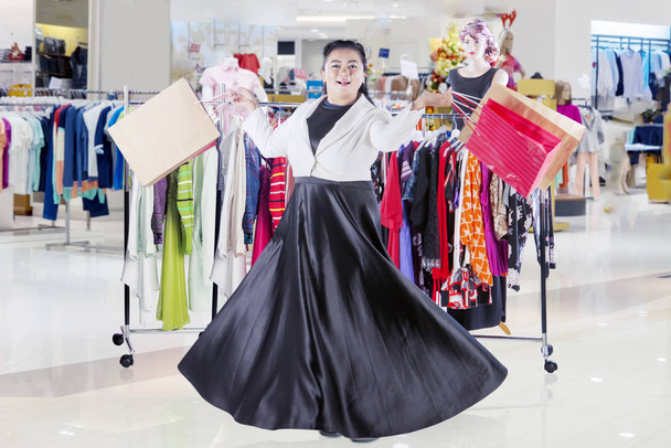 Asian woman dancing happily in a clothing store - Photo, image