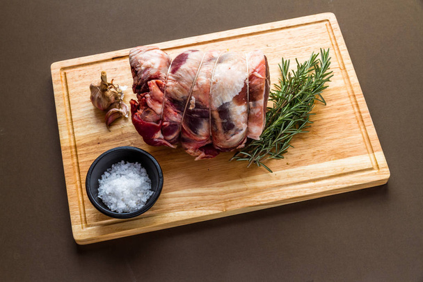 Raw rolled and tied Herdwick Sheep lamb joint with garlic, rosem - 写真・画像