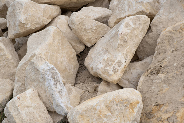 Grande pilha de grandes pedras de areia que colocam no chão de constructi
 - Foto, Imagem