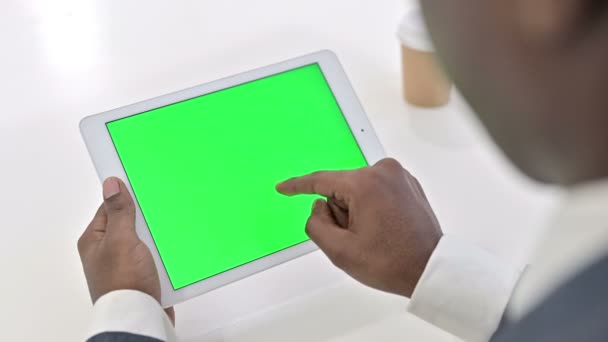 Widok z tyłu African Man za pomocą tabletu z ekranem Chroma Key - Materiał filmowy, wideo
