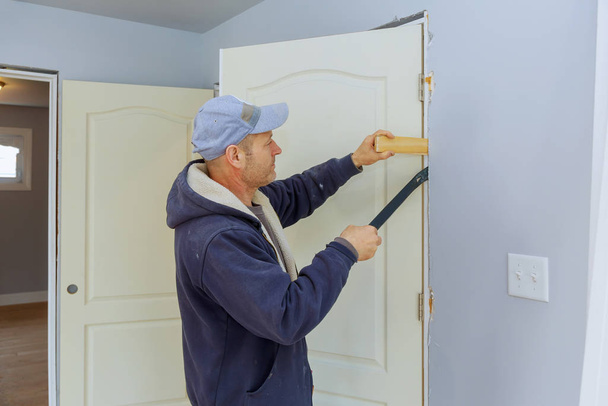 Handyman install the new door in the interior room - Photo, Image