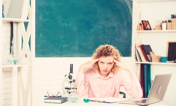 Stressful educator. Teacher stressful occupation. Stressful scientist. Girl tired stressful expression with laptop and microscope working investigation biology and chemistry. Pressure nervous tense - 写真・画像