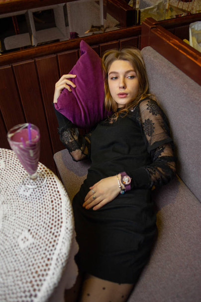Mädchen im schwarzen Kleid mit einem Cocktail in einem Café - Foto, Bild