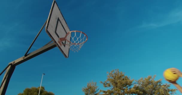 Hombre jugador de baloncesto slam dunking en una cancha de baloncesto al aire libre
. - Metraje, vídeo