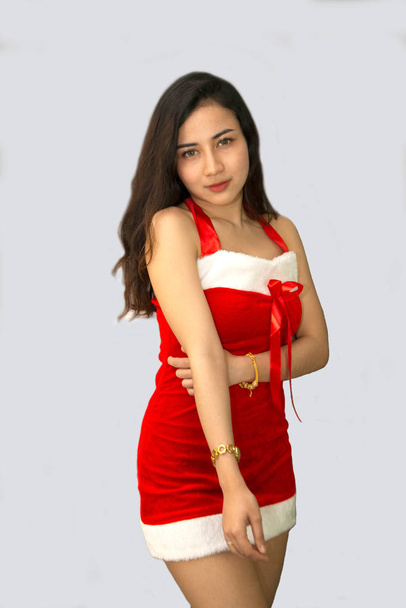 Beautiful Asian woman dressed in red in a Santa outfit. Standing and smiling at Christmas And act in different ways.  - Valokuva, kuva