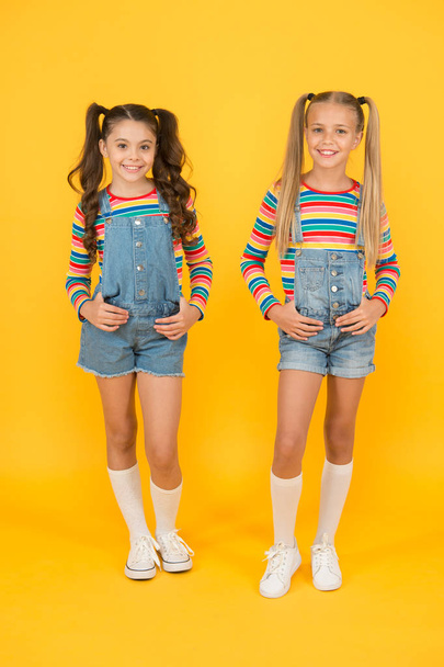 Trendy and fancy. Little girls wearing rainbow clothes. Matching outfits. Fashion shop. Must have accessory. Vibrant colors. Modern fashion. Kids fashion. Girls long hair. Cute children same outfits - Фото, изображение