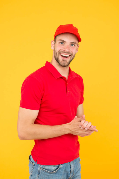 Postman delivery worker. Man red cap yellow background. Delivering purchase. Already ready. Easing your business. Service delivery. Salesman and courier career. Courier and delivery service - Fotografie, Obrázek