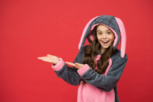 Product sale. Happy girl in bunny pajamas show empty hands for product. Presenting product. Product promotion. Sale and discount. Promoting and marketing. Your advertising, copy space - Photo, Image