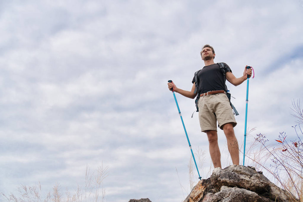 man hiker on rocky peak of mountain after having travel on mount - Zdjęcie, obraz