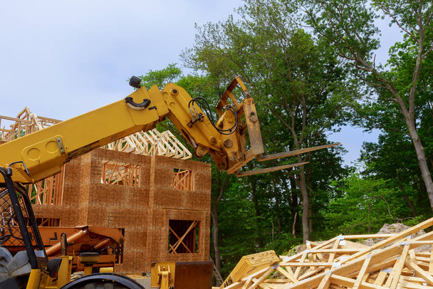 ブームトラックフォークリフトに対する新しい建設ホームフレーミング - 写真・画像