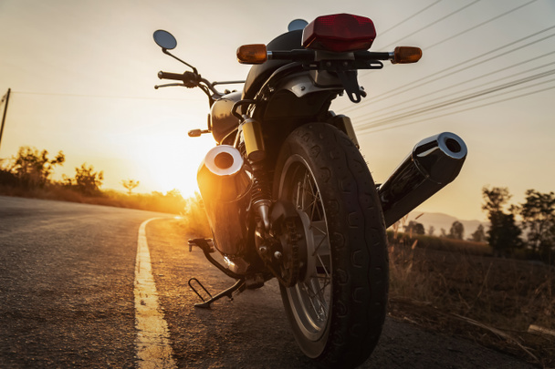 motocicleta de estilo clássico na estrada com pôr do sol
  - Foto, Imagem