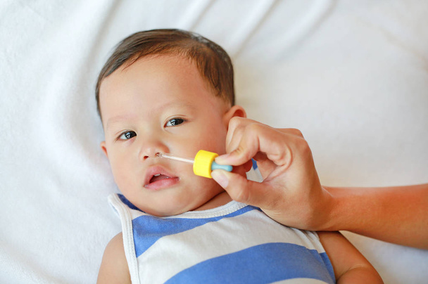 Asian baby boy gets nose drops. Baby care concept. - Fotografie, Obrázek