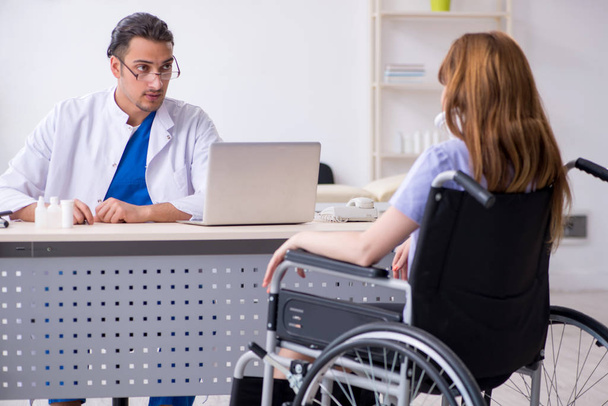 Junge Frau im Rollstuhl besucht männlichen Arzt - Foto, Bild