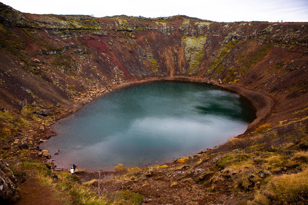 Kerid sopečné kráter jezero na Islandu. Krajina s červenými sopečnými kameny na vrcholu kráteru Kerid s modrým kráterním jezerem na Islandu - Fotografie, Obrázek