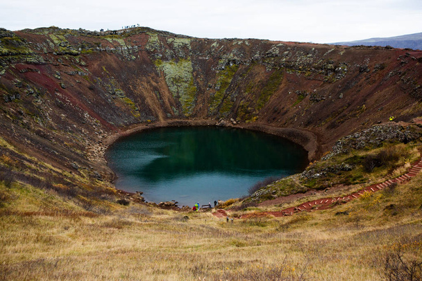 Lago del cráter volcánico Kerid en Islandia. Paisaje con piedras volcánicas rojas en la parte superior del cráter Kerid con lago de cráter azul en Islandia
 - Foto, imagen