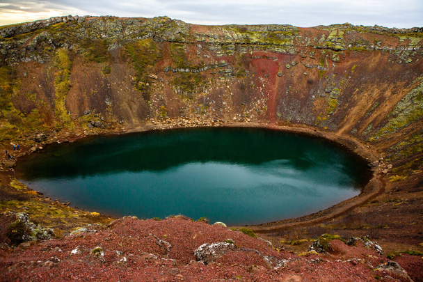 Kerid vulkanischen Kratersee in Island. Landschaft mit roten Vulkansteinen auf der Spitze des Kerid-Kraters mit blauem Kratersee in Island - Foto, Bild