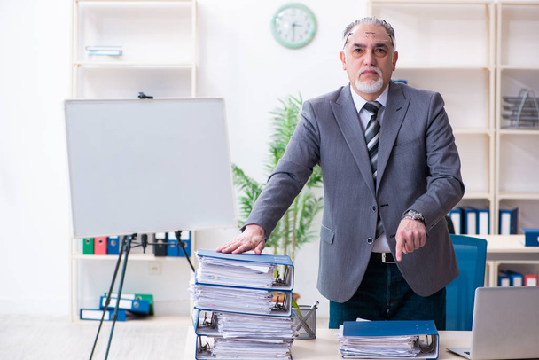 Ältere männliche Mitarbeiter unzufrieden mit exzessiver Arbeit - Foto, Bild