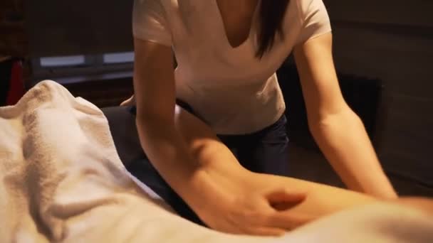 Young woman having feet massage in beauty spa salon, close up. Masseur kneads the foot and leg of a young beautiful girl. - Imágenes, Vídeo