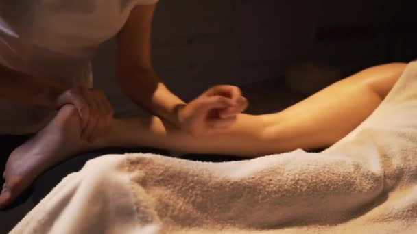 Young woman having feet massage in beauty spa salon, close up. Masseur kneads the foot and leg of a young beautiful girl. - Footage, Video