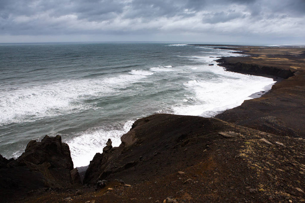 Όμορφη ακτή του Ατλαντικού Ωκεανού με βουνά. Κύματα του Βόρειου Ατλαντικού ωκεανού συντρίβονται στην παραλία στην Ισλανδία μετά από μια καταιγίδα. - Φωτογραφία, εικόνα