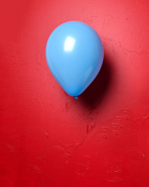 Blue latex balloon object for birthday or valentines day party on red - Photo, image