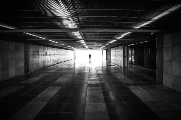Silhouette de personne méconnaissable et lumière du jour devant dans le tunnel du métro - Photo, image