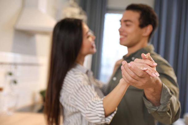 Lovely young interracial couple dancing at home, focus on hands - Фото, зображення