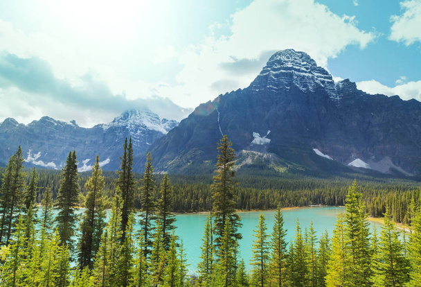 Escena serena junto al lago de montaña en Canadá con reflejo de las rocas en el agua tranquila. - Foto, imagen