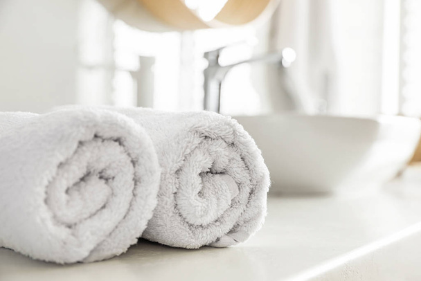 Clean rolled towels on countertop in bathroom - Fotoğraf, Görsel