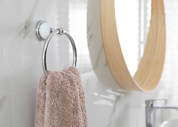 Holder with clean towel on light wall in bathroom - Foto, Imagen