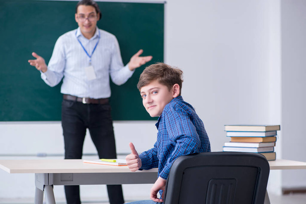 Young male teacher and boy in the classroom - Fotoğraf, Görsel