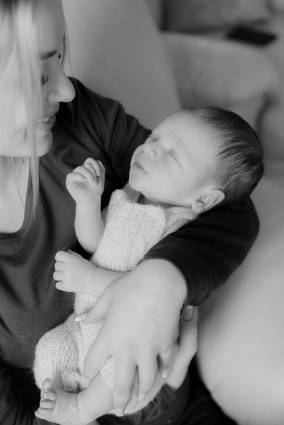 Evinde kucağında bir bebekle güzel sarı saçlı mamaso. Mutlu annelik - Fotoğraf, Görsel