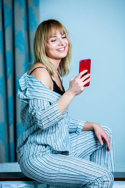Young beautiful woman awaking in light room. Relaxed woman lying in bed in sleepwear. good morning concept - young woman wake up with happy smile on her face. - Photo, Image