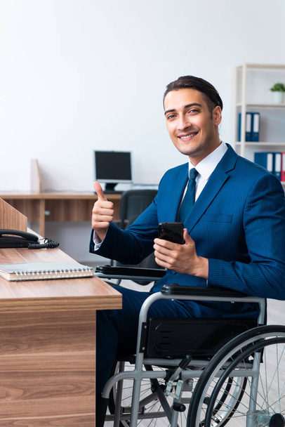 Νεαρός άνδρας υπάλληλος σε αναπηρική καρέκλα - Φωτογραφία, εικόνα
