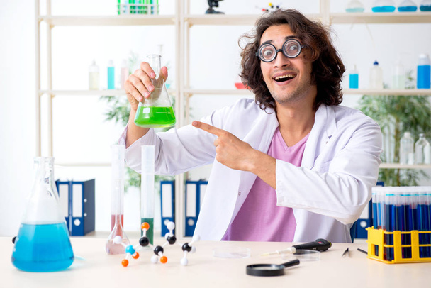 Grappige mannelijke chemicus die in het lab werkt - Foto, afbeelding