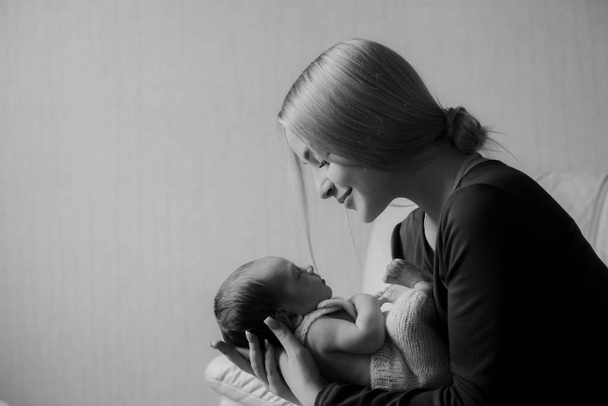 Young beautiful blond hair mamaso with a baby in her arms at home. Happy motherhood - Foto, immagini