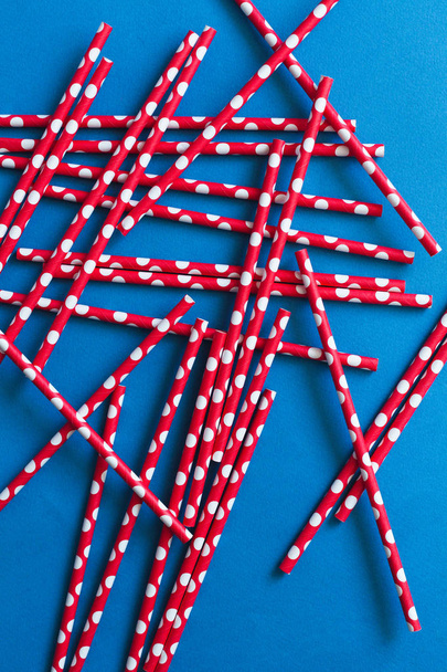 Red cocktail straws on a blue background - Photo, Image