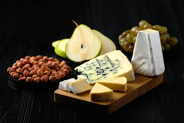 Low key photo of assortment of cheese and snack for wine - Fotografie, Obrázek