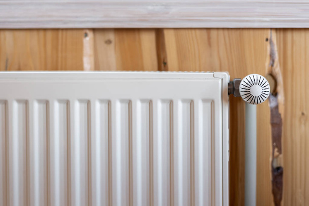 Fehér modern radiátor a szobában fából készült fallal és hangulatos belső - Fotó, kép