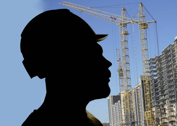 фото силуэт Рабочий человек в трудной шляпе, человек носить шлем на фоне высоких зданий
.  - Фото, изображение