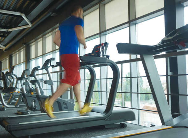  Young man training on treadmill.  - Foto, Bild