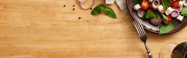 felülnézet ízletes olasz zöldség saláta panzanella tálalva tálcán fa asztalon közelében friss összetevők, villa és vörösbor, panorámás lövés - Fotó, kép